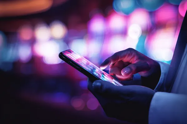 JILI696 Slots — Thousands of thrilling machines await A woman smiling by bright slot machines showing lucky symbols, showcasing the exciting slot offerings at JILI696.